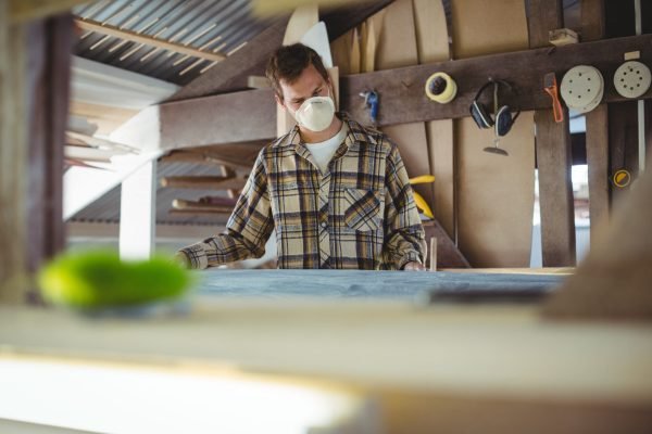 Man making surfboard in workshop